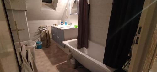 een badkamer met een bad en een wastafel bij Chez Laurent in Mérignies
