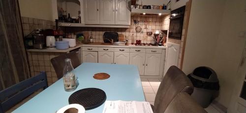 eine kleine Küche mit einem blauen Tisch und Stühlen in der Unterkunft Chez Laurent in Mérignies