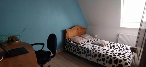 een slaapkamer met een bed, een bureau en een stoel bij Chez Laurent in Mérignies