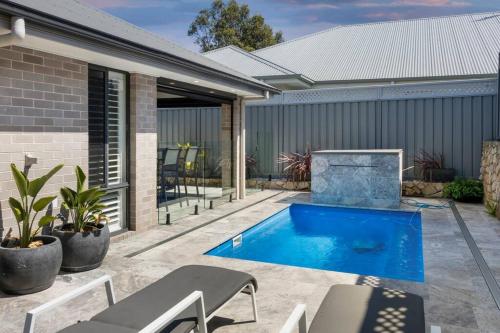 a backyard with a swimming pool and a house at Rengor Executive Retreat in Belmont