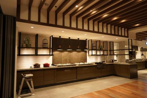 a large kitchen with brown cabinets and a stool at Gokulam Grand Trivandrum in Trivandrum