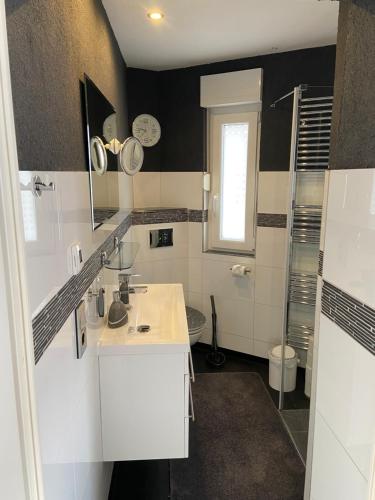 biała łazienka z umywalką i prysznicem w obiekcie Ferienwohnung Sarah w mieście Schönebeck