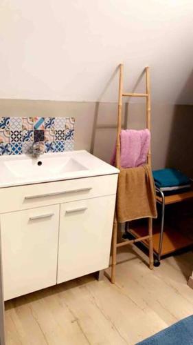 une salle de bain blanche avec un lavabo et une chaise dans l'établissement Location duplex tout confort, à Erquinghem-Lys