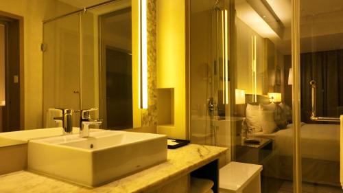 a bathroom with a sink and a shower at Gokulam Grand Trivandrum in Trivandrum