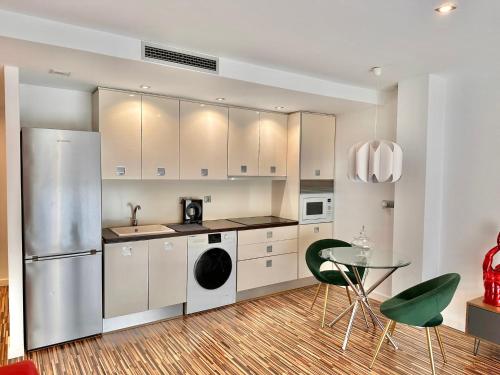 una cucina con frigorifero, tavolo e sedie di Apartamento céntrico con plaza de garaje y piscina a Murcia