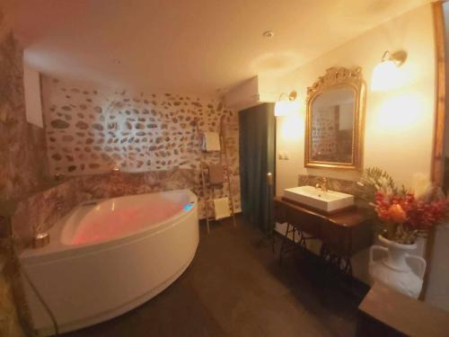baño grande con bañera y lavamanos en L'antre d'Eros, en Romans-sur-Isère