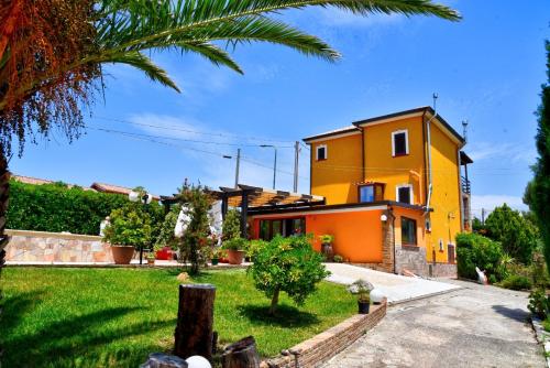 a yellow house with a palm tree in front of it at Simo Amour in Lercara Friddi