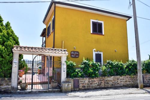 a yellow house with a gate and a fence at Simo Amour in Lercara Friddi