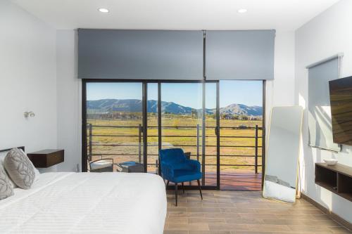a bedroom with a bed and a view of a field at Cabaña en el Valle in Ensenada