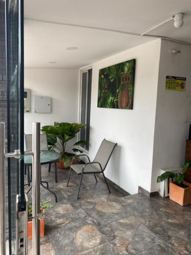 a living room with two chairs and a table at Hotel Arrendajo in Acacías