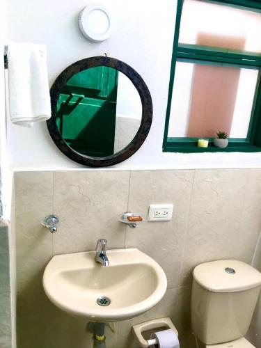 a bathroom with a sink and a mirror and a toilet at El granadillo in Villa de Leyva