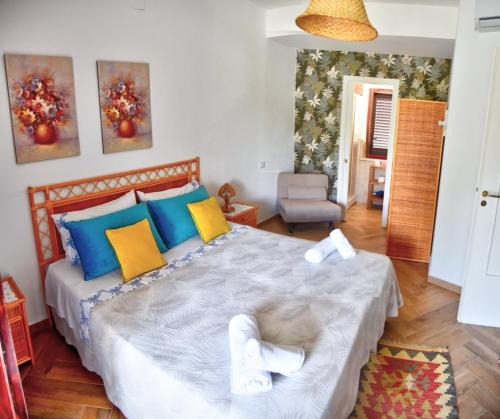 a bedroom with a large bed with blue and yellow pillows at Simo Amour in Lercara Friddi