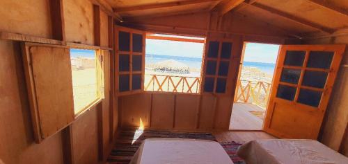 pusty pokój z dwoma łóżkami i oknem w obiekcie Starlight Camp Nuweiba w mieście Wāsiţ