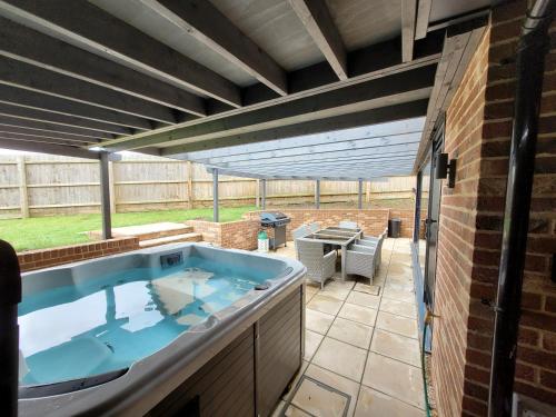 bañera de hidromasaje en el patio de una casa en Yew Tree Cottage- A beautiful cottage with Hot Tub, en Hintlesham