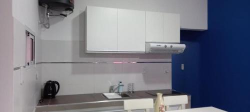 una cocina con armarios blancos y fregadero en Catamarca Apart en Ramallo