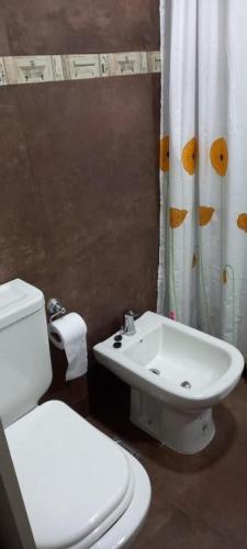 a bathroom with a white toilet and a sink at Catamarca Apart in Ramallo