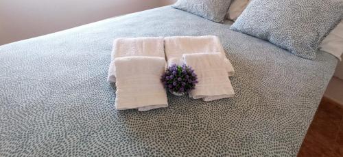 un letto con sopra asciugamani e un fiore di Bahia Sol Dream -Caleta de Fuste- a Caleta De Fuste