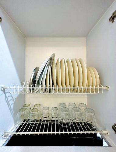 a shelf in a kitchen with glasses and utensils at 4-Bedroom Home in South Jakarta Nuansa Swadarma Residence by Le Ciel Hospitality in Jakarta