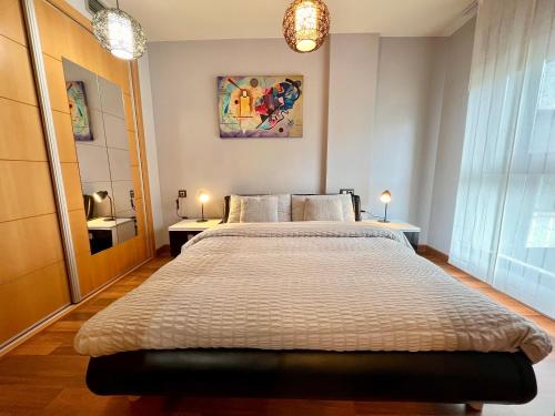 una camera con un grande letto e due lampade di Apartamento El Estrecho a Algeciras