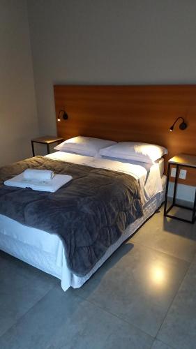 1 dormitorio con 1 cama grande y cabecero de madera en 661 Hospedagem, en São Borja