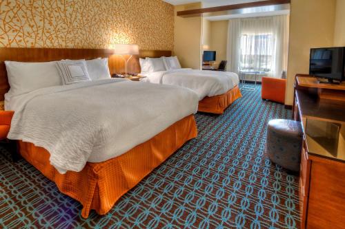 a hotel room with two beds and a flat screen tv at Fairfield Inn and Suites Oklahoma City Yukon in Yukon
