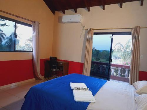 a bedroom with a bed with blue sheets and a window at Resort Sport in Independencia