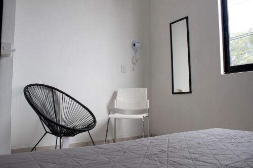 a bedroom with a bed and a chair and a mirror at Casa Salazar Guadalajara in Guadalajara