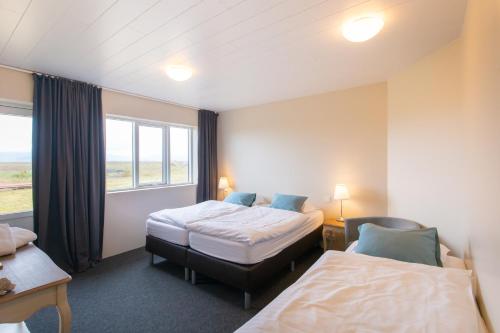 una camera d'albergo con due letti e una finestra di DalsSel farm Guesthouse a Hólmabæir