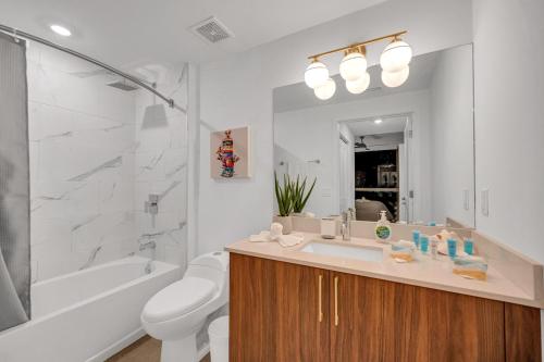 a bathroom with a sink and a tub and a toilet at Exclusive Condo in Downtown Miami With Pool Views and Free Parking in Miami