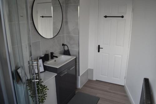 uma casa de banho com um lavatório e um espelho em Luxury Home Close to Leeds City Centre em Leeds