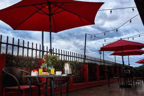 a table and chairs with red umbrellas on a patio at Sleep Inn Puebla Centro Hist rico in Puebla