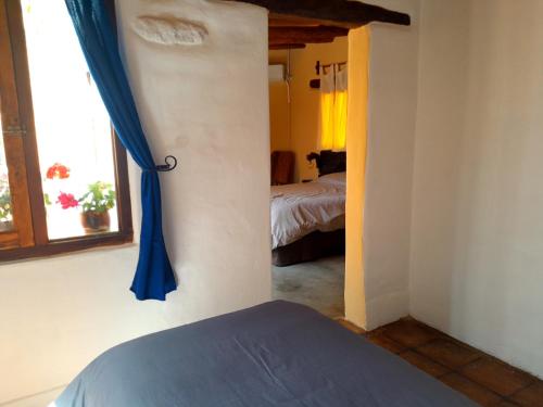 1 dormitorio con cama y cortina azul en Cabaña Pedacitos de Cielo en San Carlos