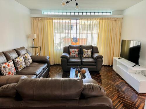 a living room with two couches and a television at Casa Verde Jesús María - Zona Residencial in Lima