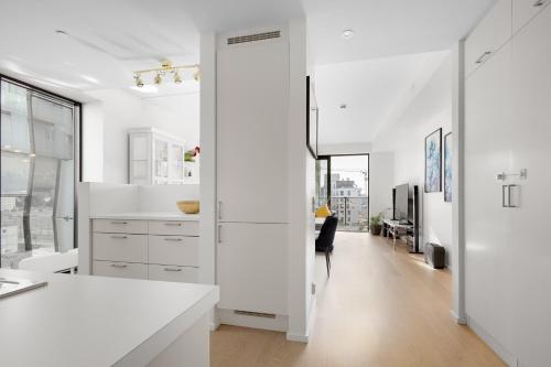 Luxurious 2BR apartment at Central OSLO BARCODE في أوسلو: مطبخ به كونترات بيضاء وممر طويل