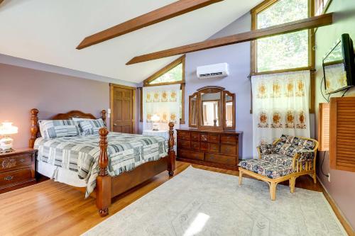 ein Schlafzimmer mit einem Bett und einem Stuhl in der Unterkunft Spacious Woodbury Home with Pool and Hot Tub! in Woodbury