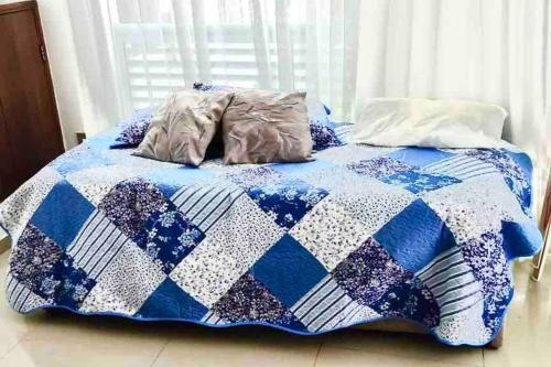 a bed with a blue and white quilt on it at Sea View 603B in San Andrés