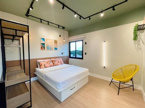 1 dormitorio con 1 cama y 1 silla amarilla en PALMAS EXPERIENCE - Apartamento Girassol, en Palmas