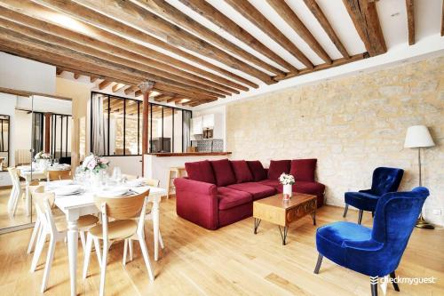 sala de estar con sofá rojo, mesa y sillas en Amazing Apartment 2BR6P - St Lazare South Pigalle, en París