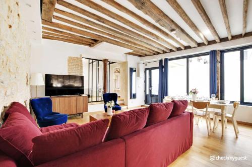 sala de estar con sofá rojo y mesa en Amazing Apartment 2BR6P - St Lazare South Pigalle, en París