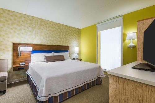 a hotel room with a bed and a television at Home2 Suites by Hilton Buffalo Airport/ Galleria Mall in Cheektowaga