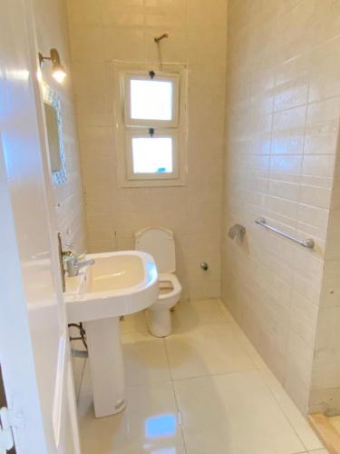 a bathroom with a sink and a toilet and a window at فيلا للإيجار مارينا 7 الساحل الشمالي in El Alamein