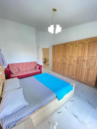 a bedroom with a bed and a couch in it at فيلا للإيجار مارينا 7 الساحل الشمالي in El Alamein