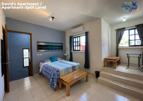 ein Schlafzimmer mit einem Bett und einer Bank darin in der Unterkunft Casa de Yoli in Cozumel