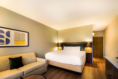 a hotel room with a bed and a couch at Sonesta Select Philadelphia Airport in Philadelphia