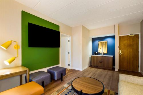 a living room with a green wall and a table at Sonesta Select Philadelphia Airport in Philadelphia