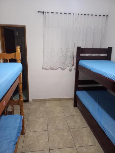 a room with two bunk beds and a window at Casa em Praia Grande -SP in Praia Grande