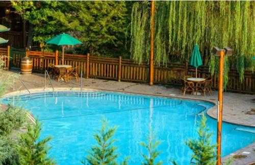 a swimming pool with an umbrella and tables and chairs at Westgate Smoky Mountain Resort & Water Park in Gatlinburg