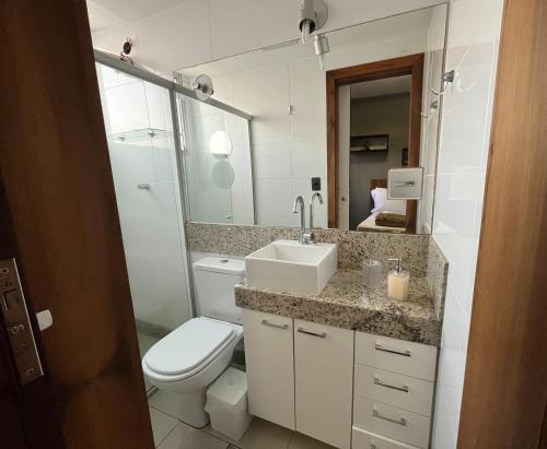 a bathroom with a toilet and a sink and a mirror at Apartamento em Belo Horizonte 2 in Belo Horizonte