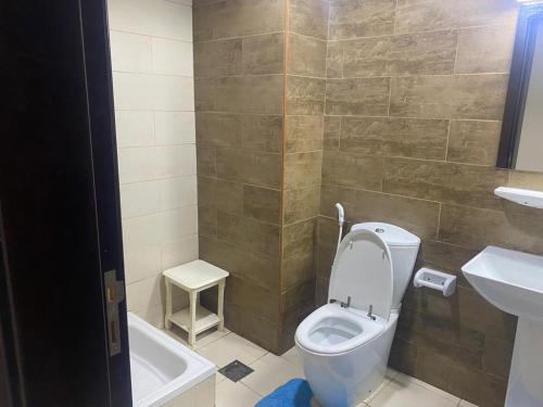 a bathroom with a toilet and a sink and a tub at Al Yasmeen Tower A in Ajman 