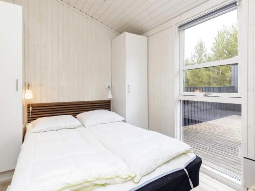 um quarto com uma cama e uma grande janela em Holiday home Jerup LX em Jerup